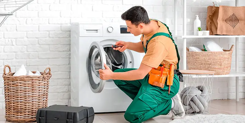 Electrocaser, operario arreglando lavadoradora con el servicio reparación de averías del Seguro de hogar